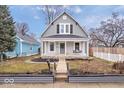 Inviting two-story gray home with a charming front porch swing and well-kept lawn at 1224 N Olney St, Indianapolis, IN 46201
