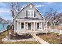 Attractive gray home with a quaint front porch and a beautifully landscaped front yard at 1224 N Olney St, Indianapolis, IN 46201