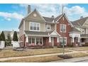 Beautiful multi-level townhome with brick accents, a covered front porch, and inviting curb appeal at 1225 Middlebury Dr, Westfield, IN 46074