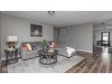 Comfortable living room featuring hardwood floors, neutral paint, a plush couch, and stylish decor at 13446 N Carwood Ct, Camby, IN 46113