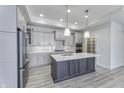 Modern kitchen featuring gray cabinets, stainless steel appliances, a large island and quartz countertops at 16799 Imperial Ct, Fishers, IN 46040