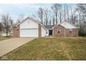 A charming brick and vinyl sided single Gathering home boasts an attached garage and well-kept lawn at 17051 Rainier Cir, Westfield, IN 46062