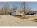 Spacious driveway leading to a three-car garage of a traditional brick home at 1824 Jutland Dr, Carmel, IN 46032