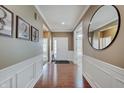 Welcoming foyer with hardwood floors, wainscoting, decorative art, and a modern mirror at 1824 Jutland Dr, Carmel, IN 46032