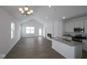 Bright, open-concept living space with hardwood floors, modern fireplace, and a kitchen island with gray countertop at 1841 James Pierce Dr, Shelbyville, IN 46176