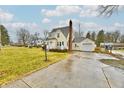 Charming yellow two-story home with an attached garage and a concrete driveway at 19 Orchard Ln, Anderson, IN 46011