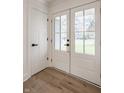Bright foyer featuring a white door, hardwood floors, and natural light from the exterior doors at 220 Pine Dr, Indianapolis, IN 46260