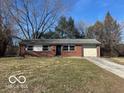 Charming brick ranch-style home with a well-manicured front lawn and an attached garage at 2306 John Glenn Ct, Indianapolis, IN 46229