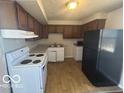A functional kitchen features laminate countertops, wood cabinets, and essential appliances at 2306 John Glenn Ct, Indianapolis, IN 46229
