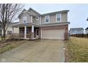 Charming two-story home with a brick and vinyl facade, attached two-car garage, and covered front porch at 2336 Boneset Dr, Plainfield, IN 46168