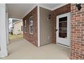 A covered front porch with brick pillars, and a white front door with glass panels at 2336 Boneset Dr, Plainfield, IN 46168