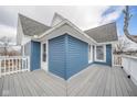 View of the outdoor deck on a blue home with white railing and wood plank flooring at 300 E North Main St, Summitville, IN 46070
