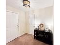Hallway with neutral walls, carpet flooring, black storage cabinet, and two white doors at 327 Maxwell Rd, Indianapolis, IN 46217
