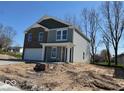 Charming two-story home showcasing a brick facade, gray siding, and a well-maintained lawn at 3825 Windstar Way, Columbus, IN 47203