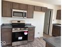 Modern kitchen featuring stainless steel appliances, granite countertops, and dark cabinets at 3825 Windstar Way, Columbus, IN 47203
