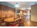 Inviting dining area with wooden floors, a classic light fixture, and an adjacent kitchen at 5982 Oak Hill East Dr, Plainfield, IN 46168