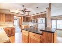 Well-lit kitchen featuring wooden cabinets, stainless steel appliances, a center island, and an eat-in dining area at 5982 Oak Hill East Dr, Plainfield, IN 46168