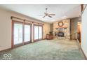 Spacious living room with stone fireplace and large glass sliding doors leading to an outdoor deck at 5982 Oak Hill East Dr, Plainfield, IN 46168