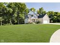 Charming two-story home with a large lawn and mature trees surrounding the property at 6208 W Foster Ridge Ln, Pendleton, IN 46064