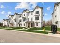 A stylish neighborhood of modern townhomes featuring well-kept lawns and striking architectural details at 7070 Nine Penny Dr, Brownsburg, IN 46112