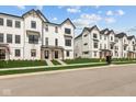 Charming row of modern townhomes with black trim, manicured lawns, and inviting curb appeal at 7070 Nine Penny Dr, Brownsburg, IN 46112
