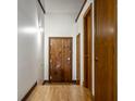 Hallway featuring hardwood floors, rustic wooden doors, and modern sconce lighting at 735 Lexington Ave # 1, Indianapolis, IN 46203