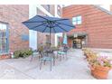 Outdoor patio with seating, umbrellas, potted flowers, and brick walls at 735 Lexington Ave # 1, Indianapolis, IN 46203