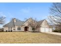 Charming brick home with a well-maintained lawn, mature trees, and a three-car garage at 7472 Windridge Way, Brownsburg, IN 46112