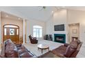 Bright living room with vaulted ceilings, a cozy fireplace, and comfortable leather furniture at 7472 Windridge Way, Brownsburg, IN 46112