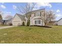 Classic two-story home featuring a well-maintained lawn, mature trees, and an attached two-car garage at 7591 Meadow Ridge Dr, Fishers, IN 46038