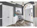 Bright foyer featuring wood floors, statement doors, neutral walls, and wainscoting, creating an open and welcoming entrance at 10896 Fairwoods Dr, Fishers, IN 46037
