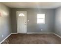 Neutral painted living room with a large window and a white front door at 118 Pennsylvania St, Shirley, IN 47384