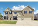 Inviting two-story home featuring a brick and siding exterior with an attached two car garage at 1395 Labrot Ct, Avon, IN 46123