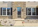 Charming front door with glass pane, surrounded by brick and siding accents, and manicured landscaping at 1395 Labrot Ct, Avon, IN 46123