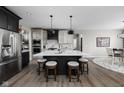 Modern eat-in kitchen with a large quartz island, stainless steel appliances, and sleek black and white cabinetry at 15675 Woodford Dr, Westfield, IN 46074