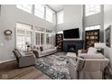 Bright living room with soaring ceilings, a cozy fireplace, large windows, and stylish decor at 15675 Woodford Dr, Westfield, IN 46074
