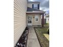 Back porch with exterior door, siding, small window, and a concrete walkway at 203 Village Green Dr, Indianapolis, IN 46227