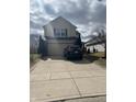 Two-story home featuring a two car garage, and a driveway with space for parking at 203 Village Green Dr, Indianapolis, IN 46227