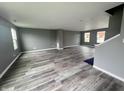 Open living room with hardwood floors, gray walls, and lots of natural light from the several windows at 215 Traditions Pass, Greenwood, IN 46143