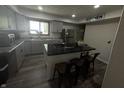 Modern kitchen with gray cabinets, island with cooktop, and stainless steel appliances at 326 W State Road 42, Mooresville, IN 46158