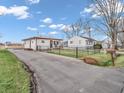 An exterior view of the home with a long driveway and charming yard, nestled in a serene neighborhood setting at 4592 Gordon Dr, Plainfield, IN 46168