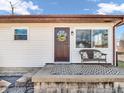 Inviting front porch featuring a decorative door, cozy bench with decorative pillows, and patterned outdoor rug at 4592 Gordon Dr, Plainfield, IN 46168