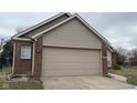 A single Gathering home featuring a large two car garage, brick and siding, and well-maintained landscaping at 4819 Lakestone Dr, Indianapolis, IN 46237