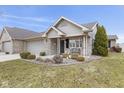 Home with landscaping, stone details, covered porch, and two-car garage at 6103 Lazy Ln, Indianapolis, IN 46259