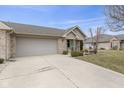 Home with two car garage, stone details and mature landscaping at 6103 Lazy Ln, Indianapolis, IN 46259