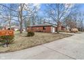 Brick home with mature trees, showing the driveway and street with address sign in the foreground at 9277 Golden Leaf Way, Indianapolis, IN 46260