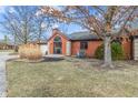 A charming home with brick exterior, a large arched window, and minimal landscaping in winter at 9277 Golden Leaf Way, Indianapolis, IN 46260