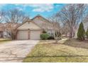 Inviting single-story home featuring a two-car garage and manicured front yard at 9694 River Oak E Ln, Fishers, IN 46038