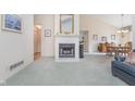 Cozy living room features a fireplace, neutral paint, and adjacent dining area at 9694 River Oak E Ln, Fishers, IN 46038