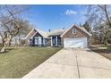 View of the home showcasing blue siding, brick accents, and a spacious driveway at 10556 Marlin Ct, Indianapolis, IN 46256